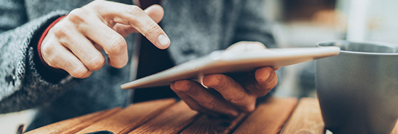 Photo d’une main parcourant les nouvelles de la Banque Nationale sur une tablette