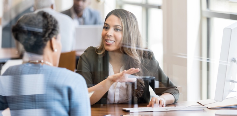 Photo de deux femmes discutant dans un bureau éclairé 