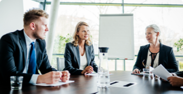 Photo de trois personnes en réunion dans un édifice à bureaux 