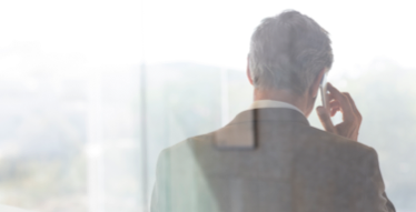 Photo d’un homme vu de dos qui parle au cellulaire 