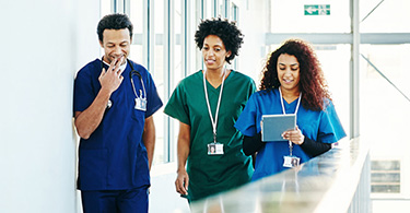 Photo de trois professionnels de la santé marchant dans un corridor