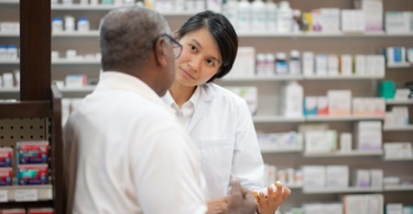 Photo de pharmacienne debout discutant avec un client