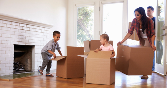 Enfants jouent dans des boîtes pendant que les parents déménagent