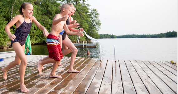 Enfants courent pour se jeter dans un lac
