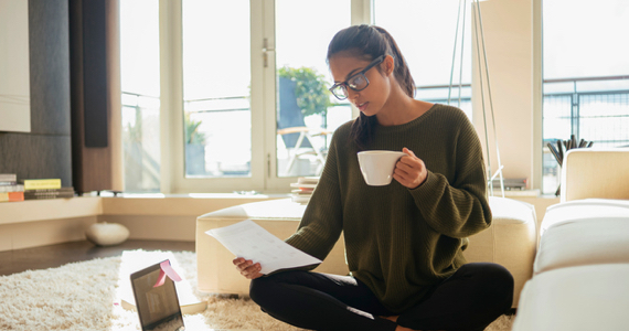 Femmes à lunettes boit un café et regarde des documents