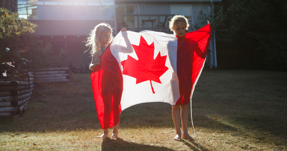 Deux enfants tiennent un drapeau du Canada
