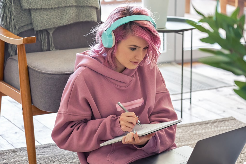 Jeune hipster avec des écouteurs sur un laptop 
