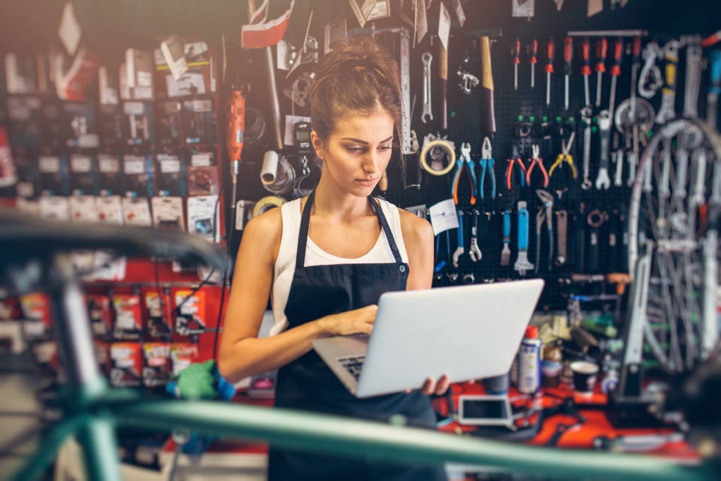 Une femme dans une boutique de velo regarde un laptop.