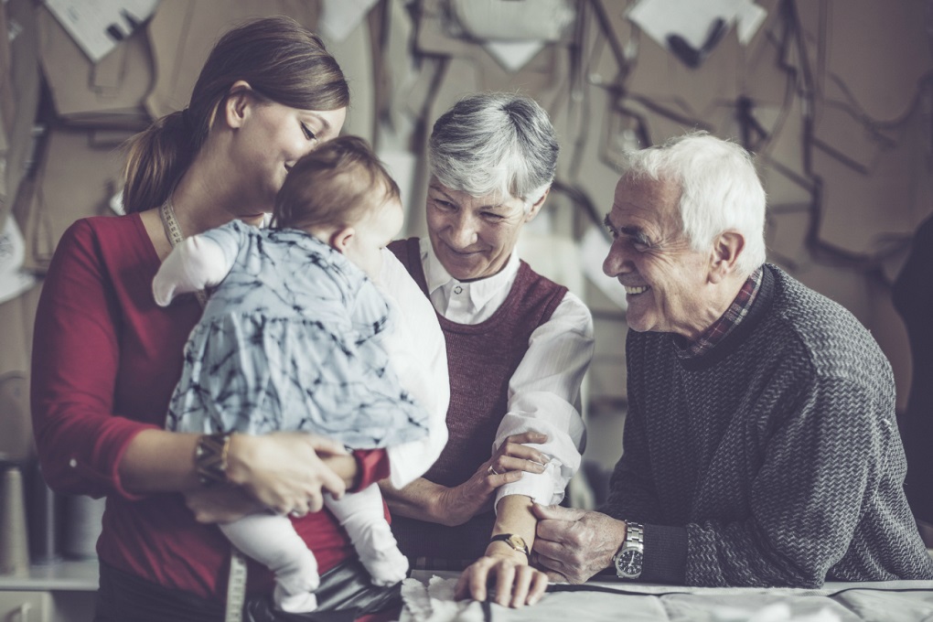 Trois générations d’une entreprise familiale partagent un moment ensemble.