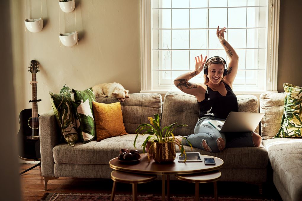 Photo d’une jeune femme heureuse dans sa maison pour un article sur l’assurance