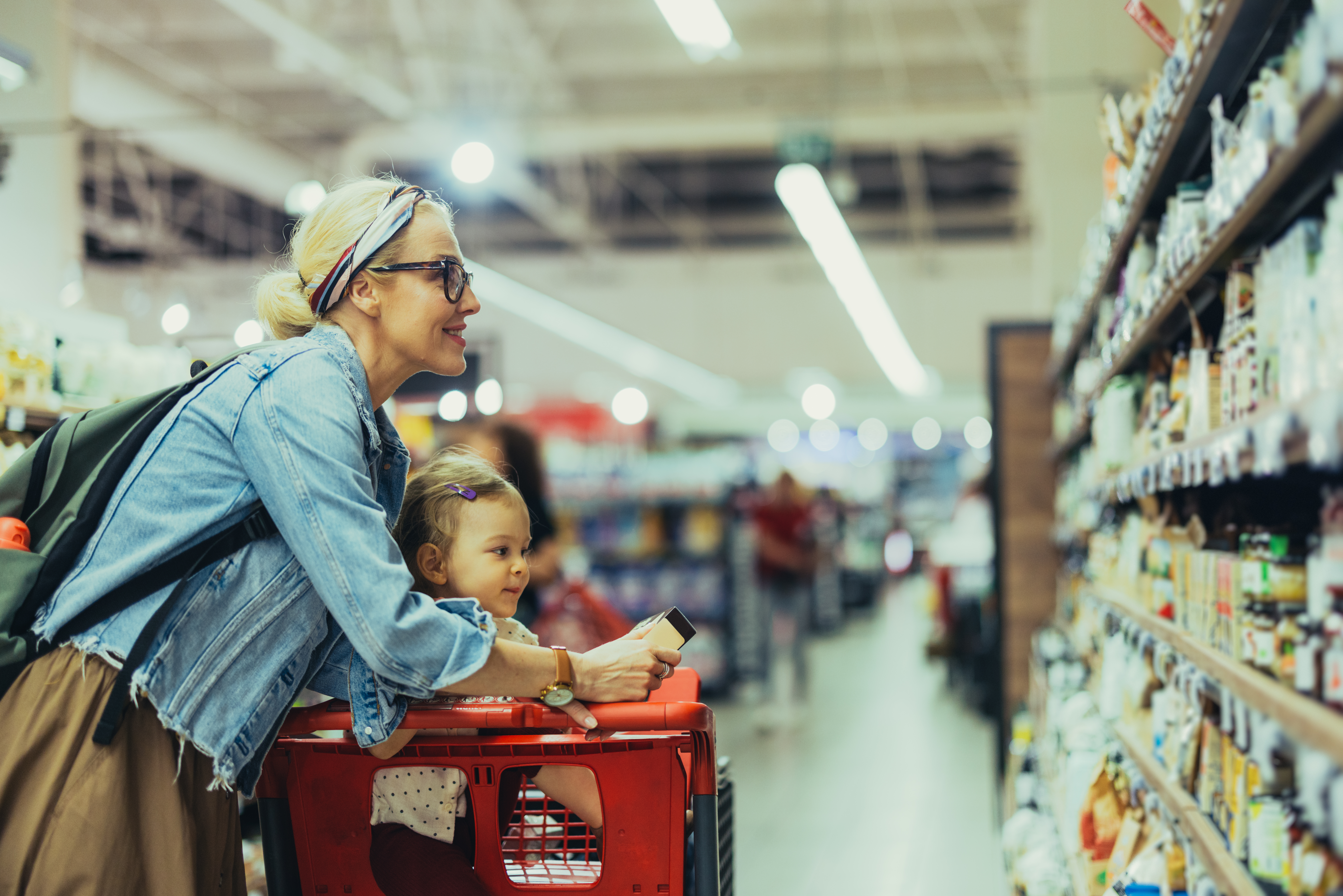 Une mère et son enfant comparant les prix des aliments à l'épicerie