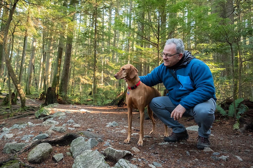 Image d'un homme retraité et son chien en balade dans la nature