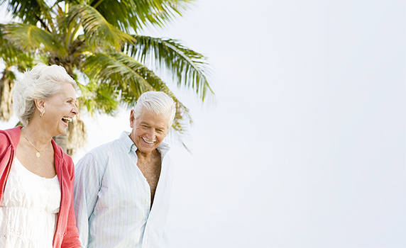 Photo d’un couple de retraités souriant et riant ensemble sur la plage en Floride 